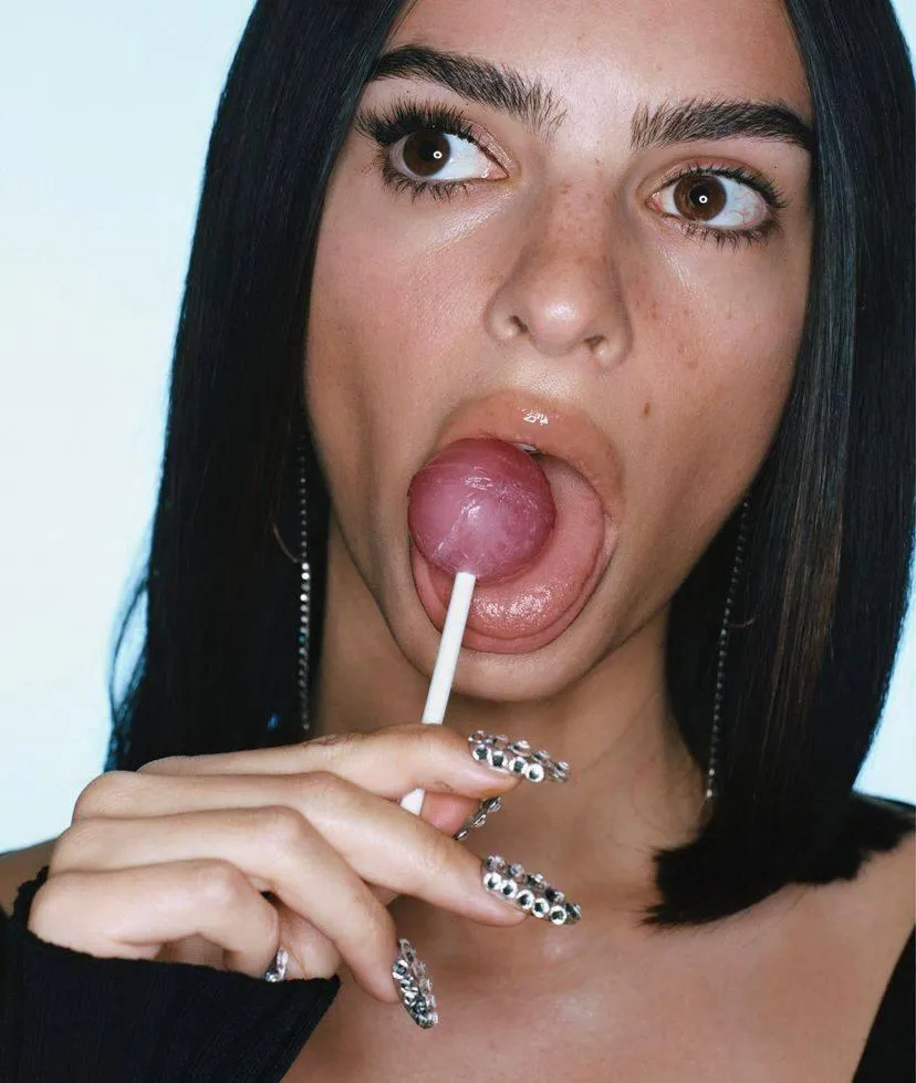 Bold close up of a woman licking a lollipop with attitude