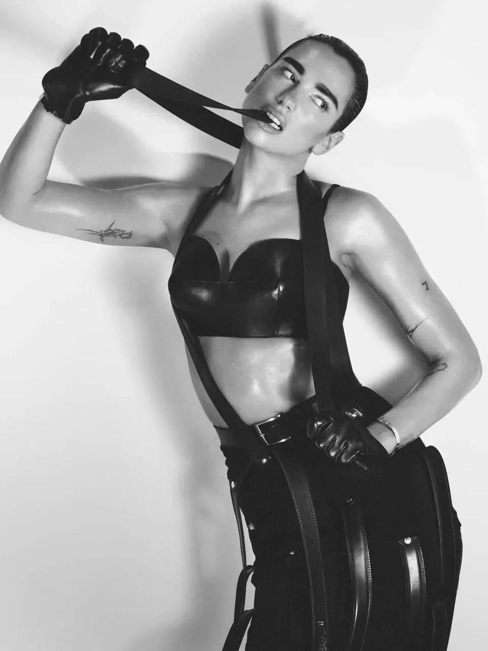 Bold woman in a latex outfit posing with a riding crop photo