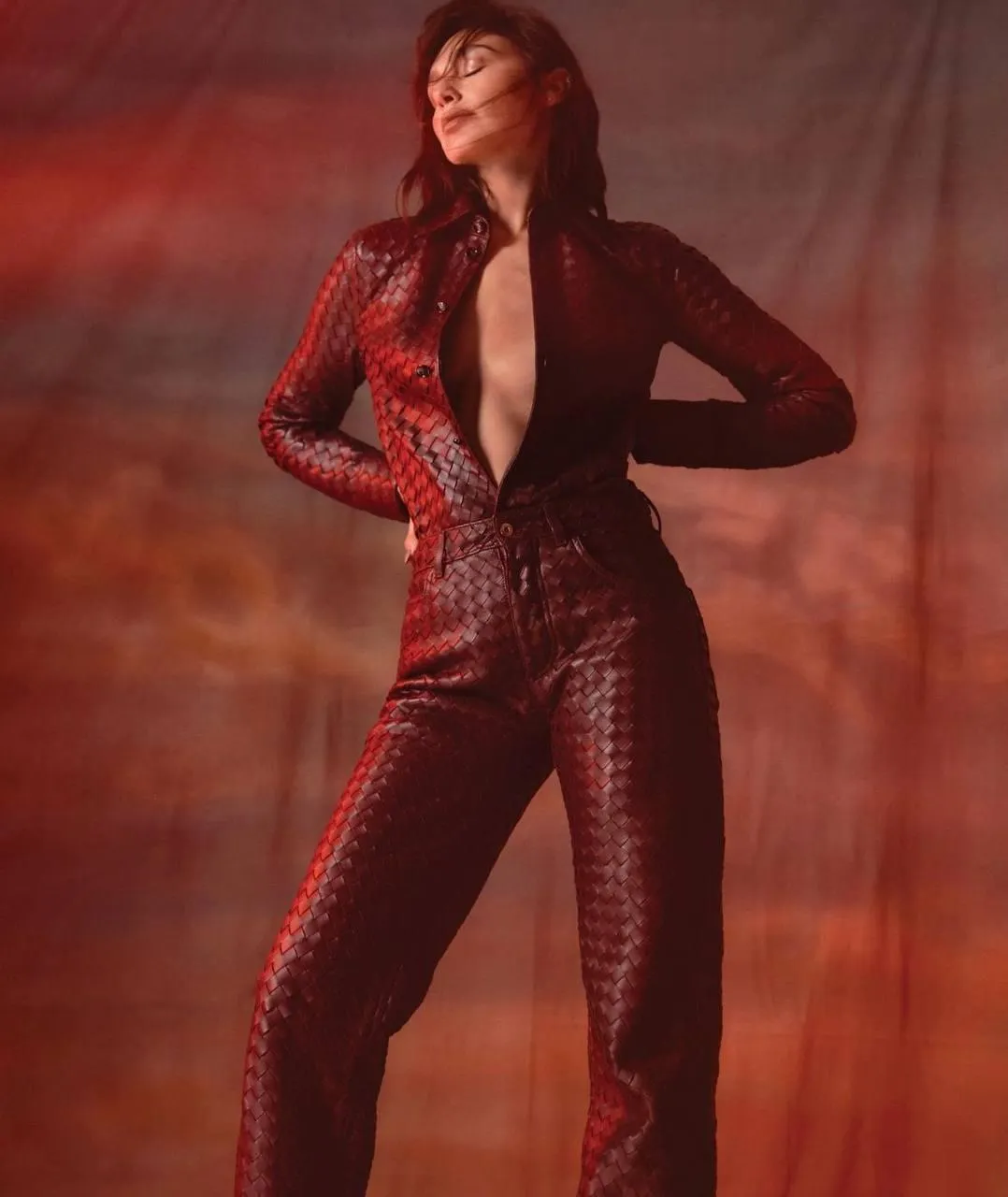 Bold woman in a red glitter bodysuit posing with confidence