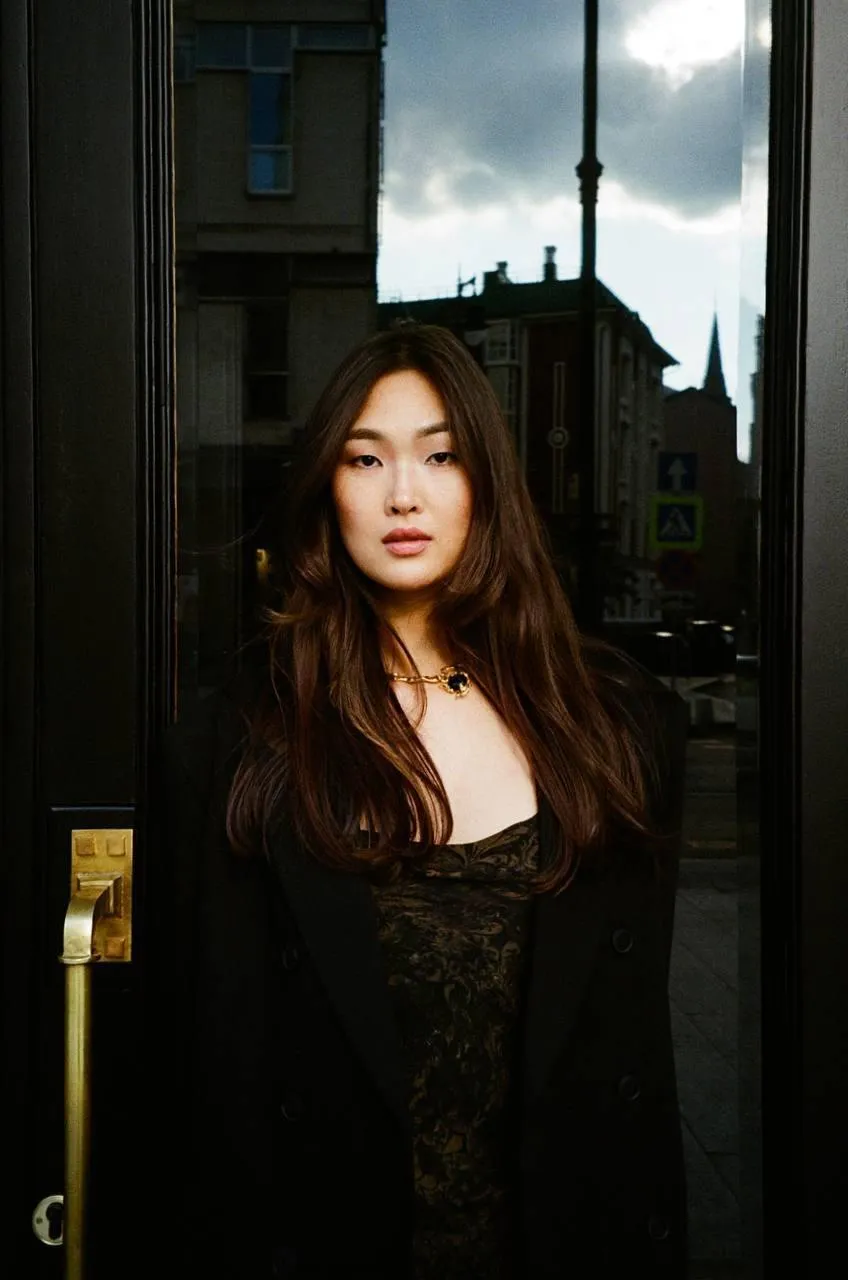 Brunette woman standing outdoors in an elegant black outfit