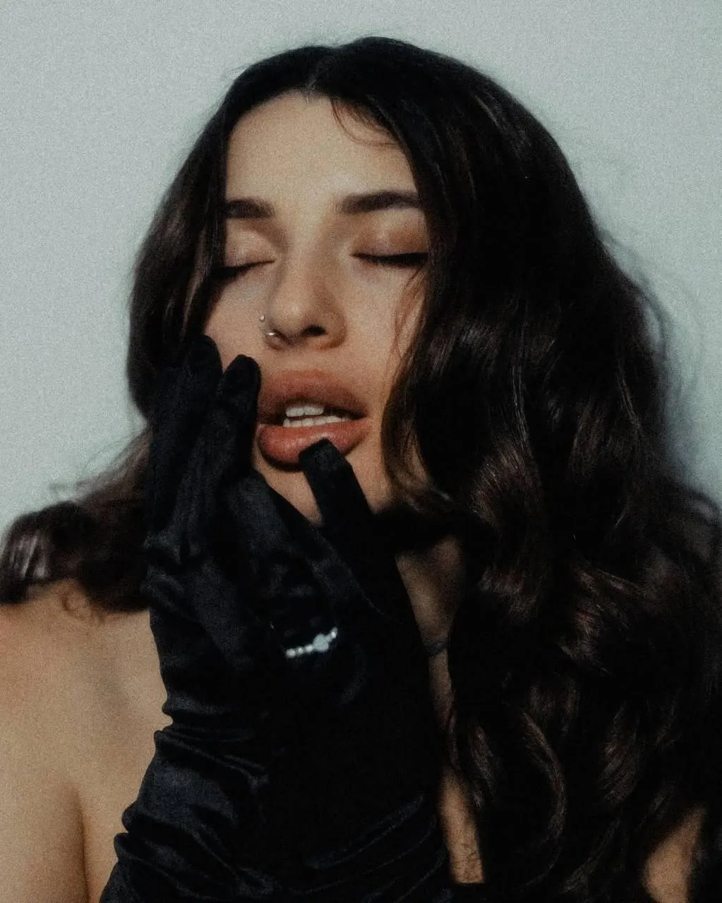 Brunette Woman with Gloves Posing in Dramatic Lighting Image