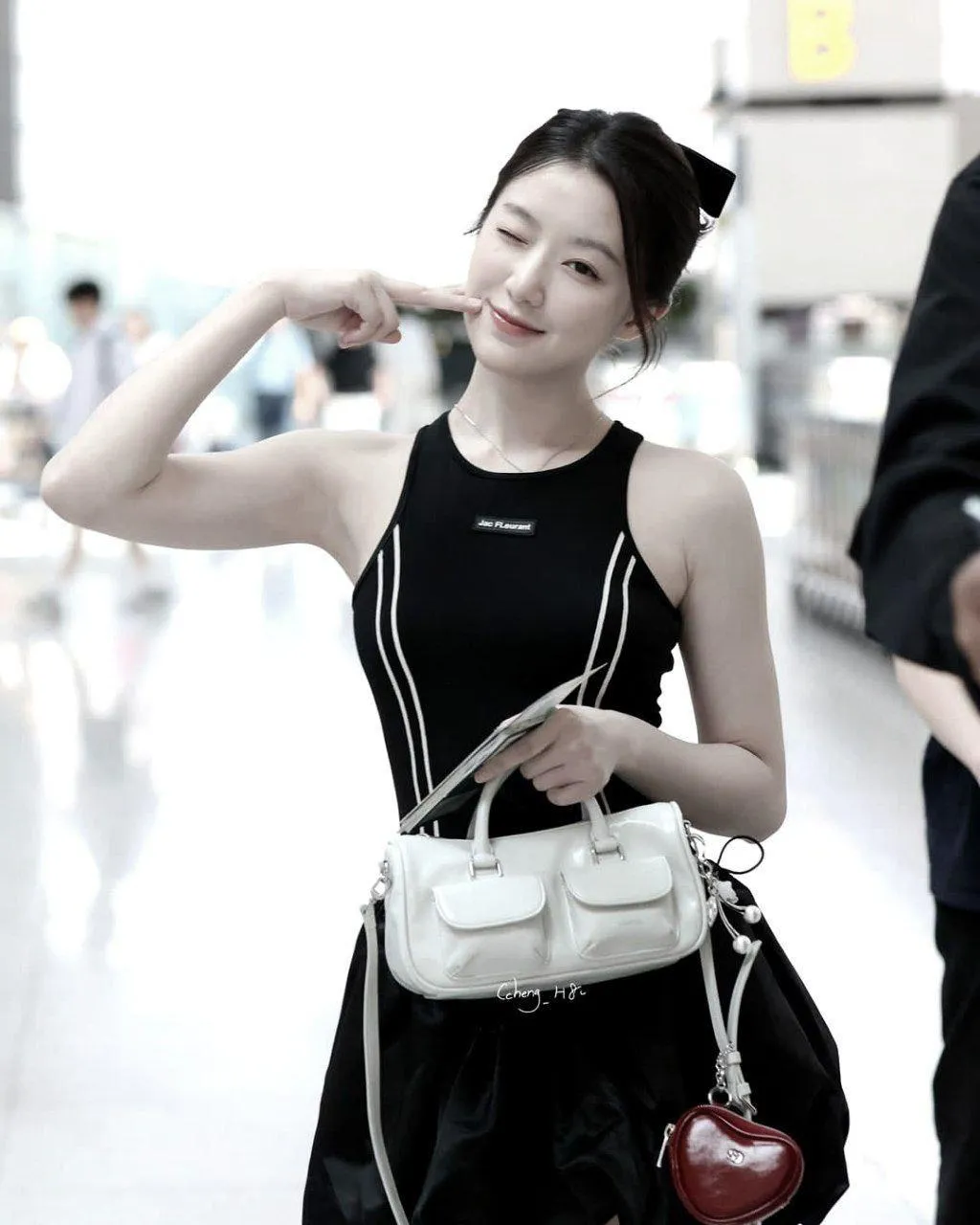 Candid Photo of a Smiling Woman in Black Dress Holding Bags
