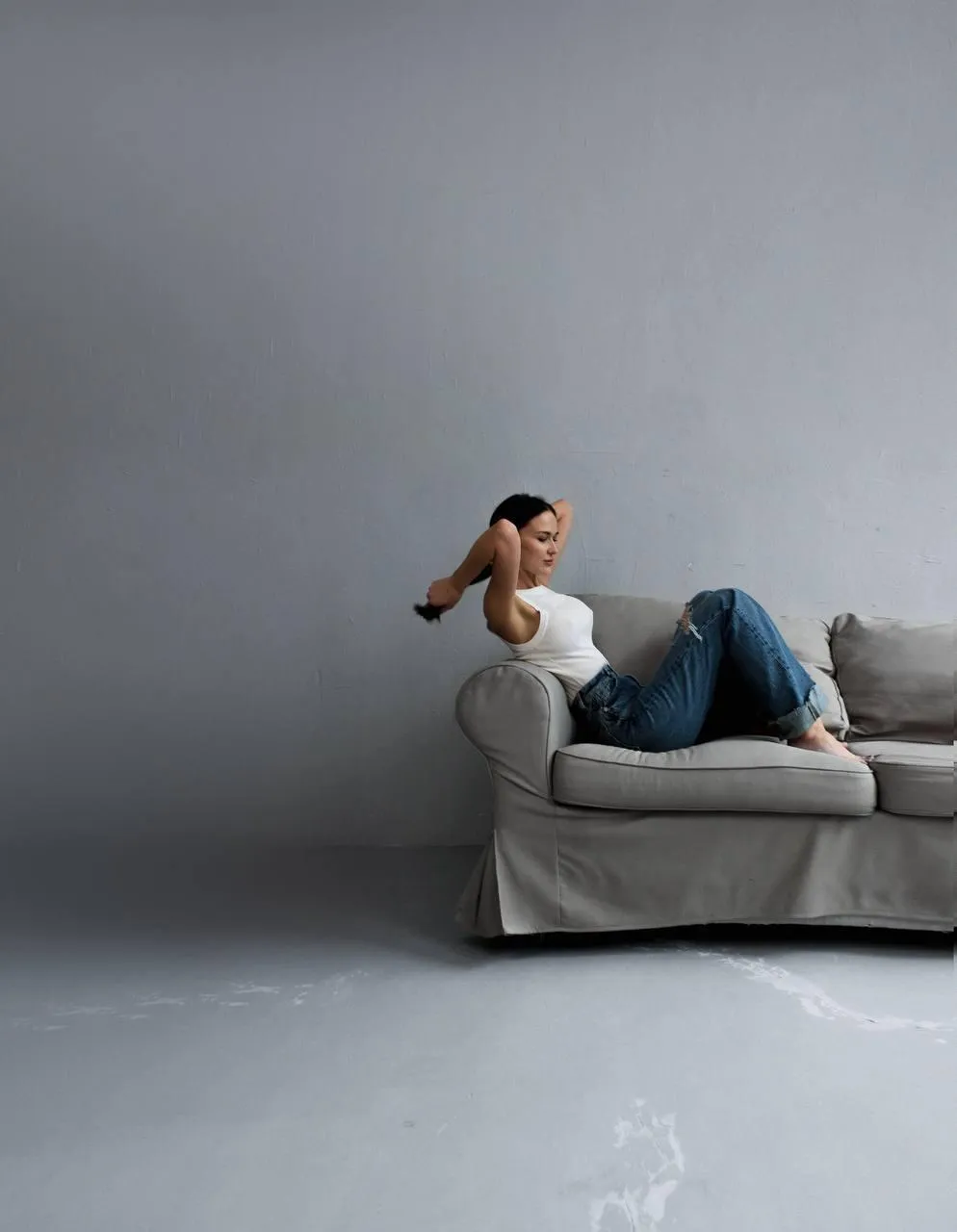 Casual woman sitting on a sofa posing in a minimalist room