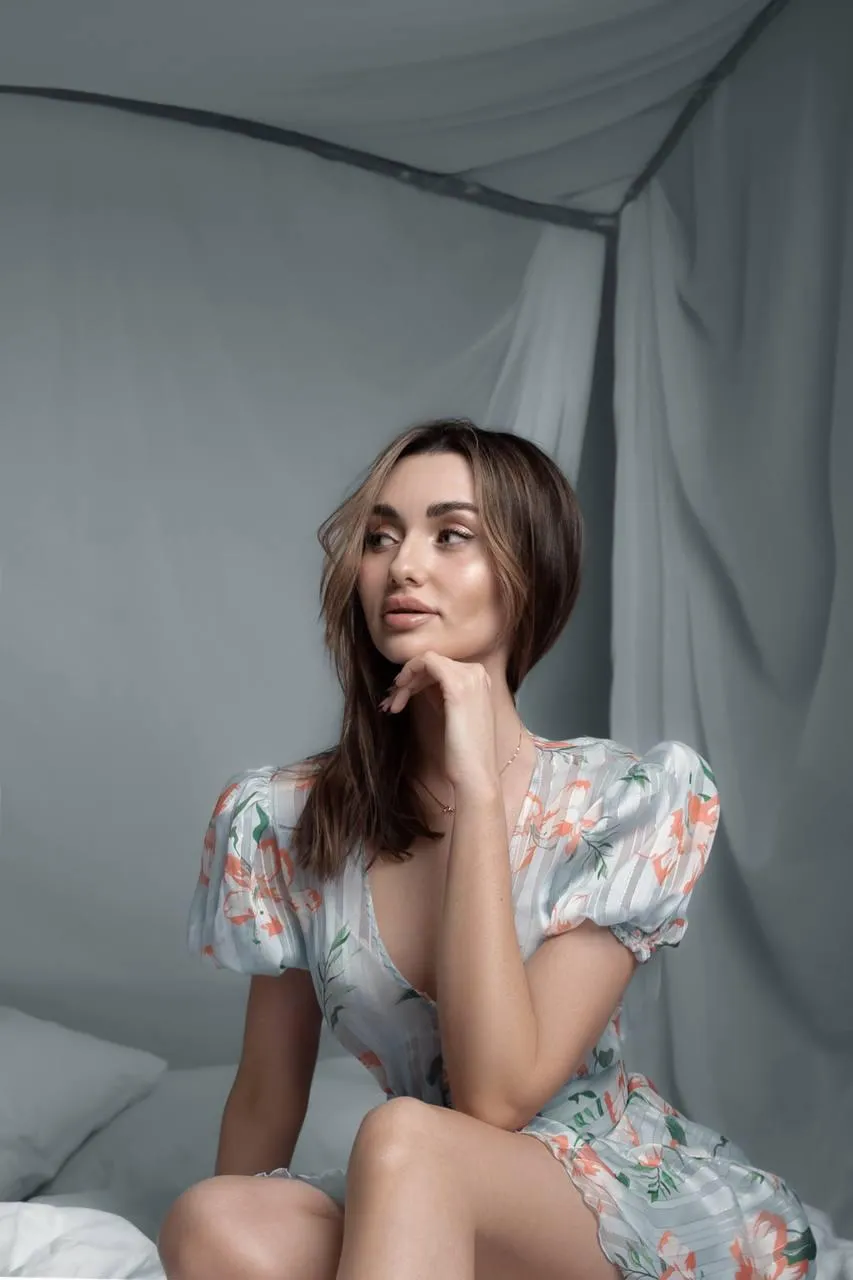Charming woman in a floral dress posing indoors softly image