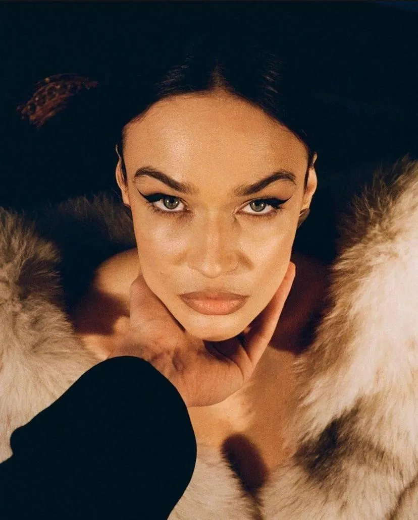 Close up of a woman in a fur jacket looking into the camera