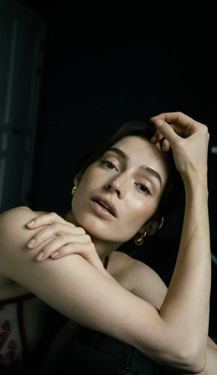 Close up of a woman sitting calmly with her hand on her head