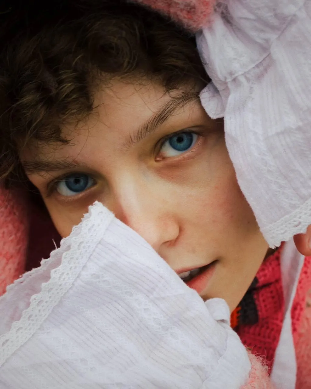 Close Up of a Woman with Blue Eyes And a White Lace Cover