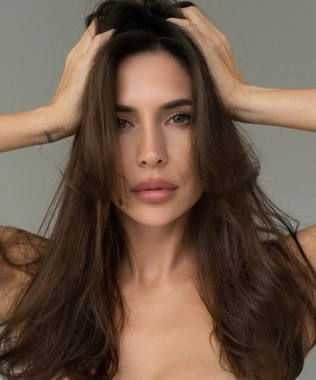 Close Up of a Woman with Long Hair Holding Head with Hands