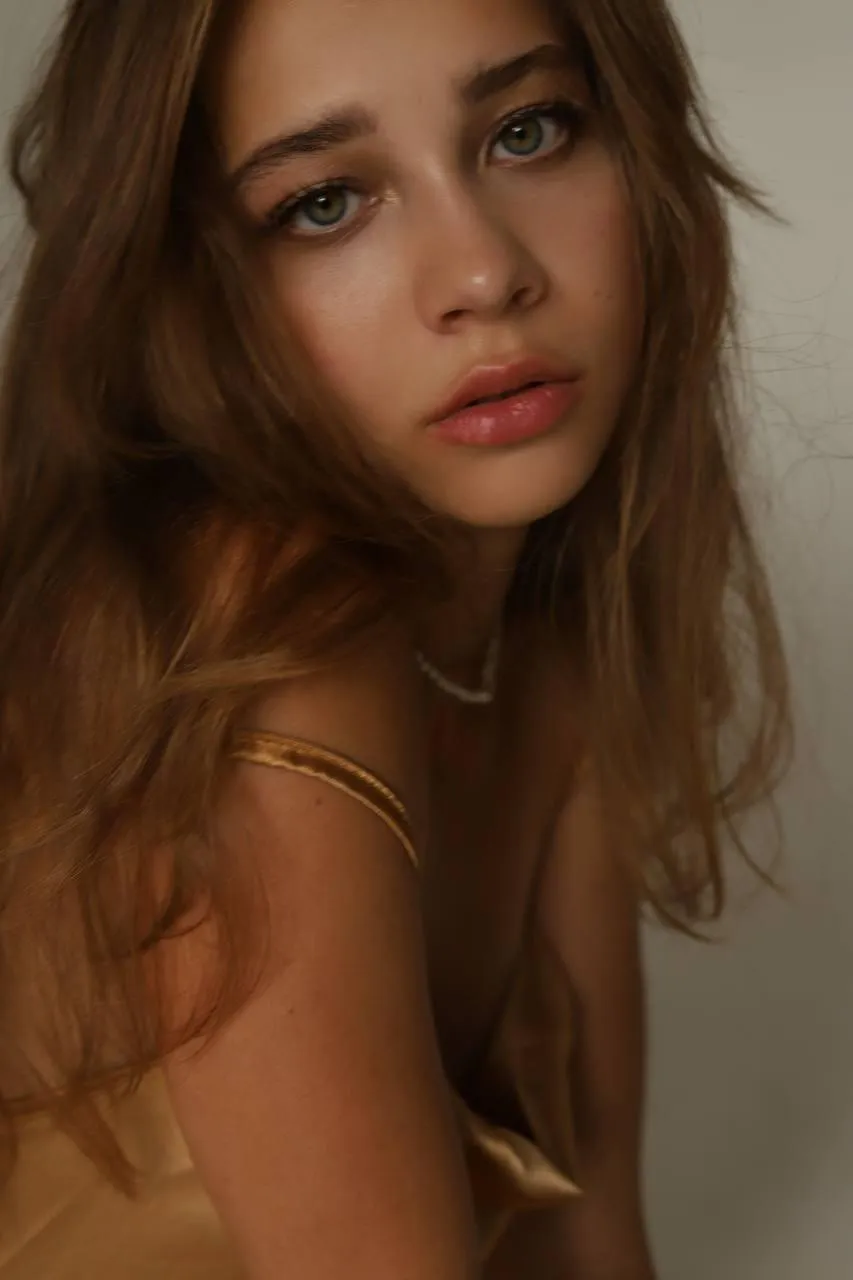 Close up of beautiful woman with long hair and golden dress