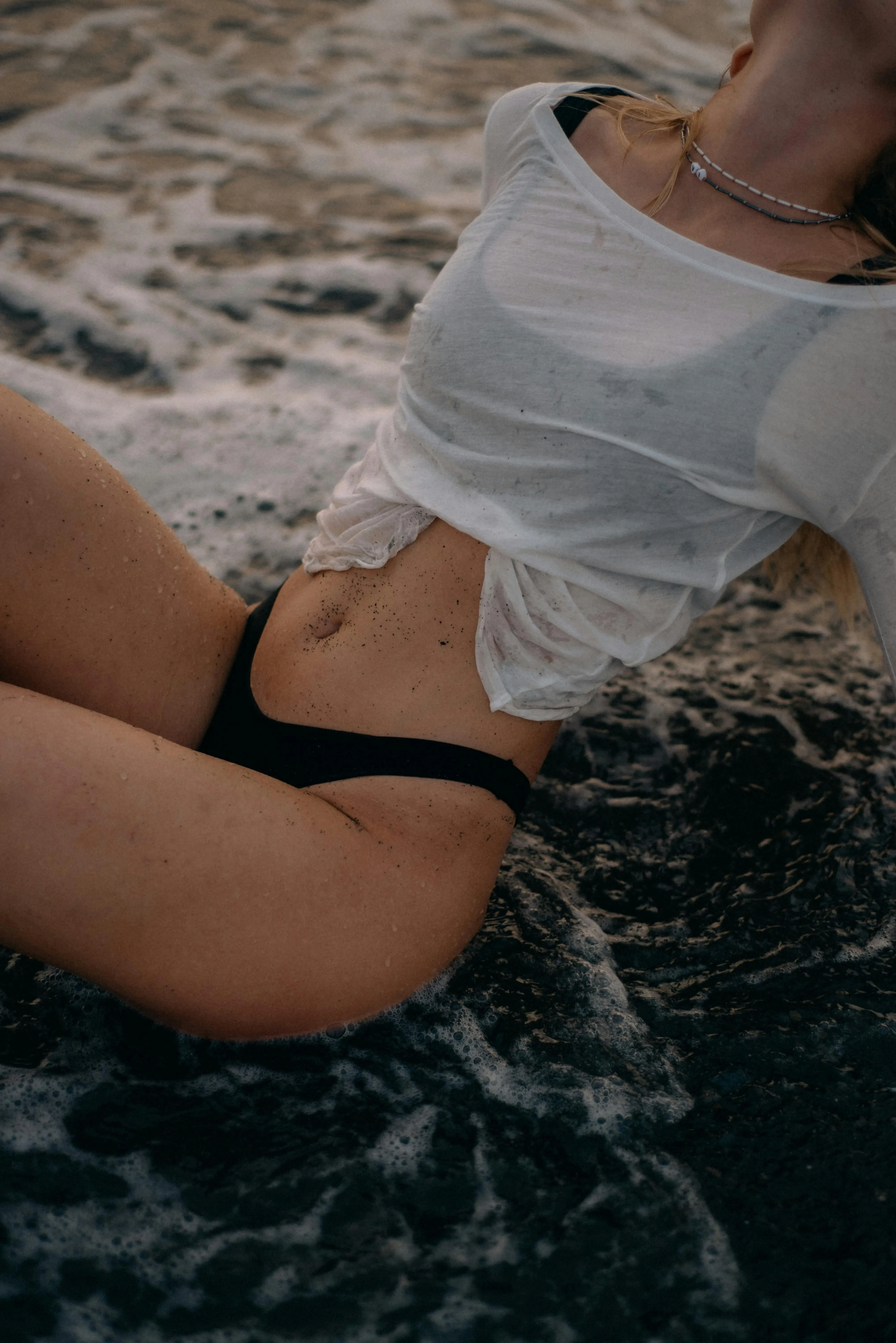 Close Up of Woman in a Wet White Top by the Shore Wallpaper