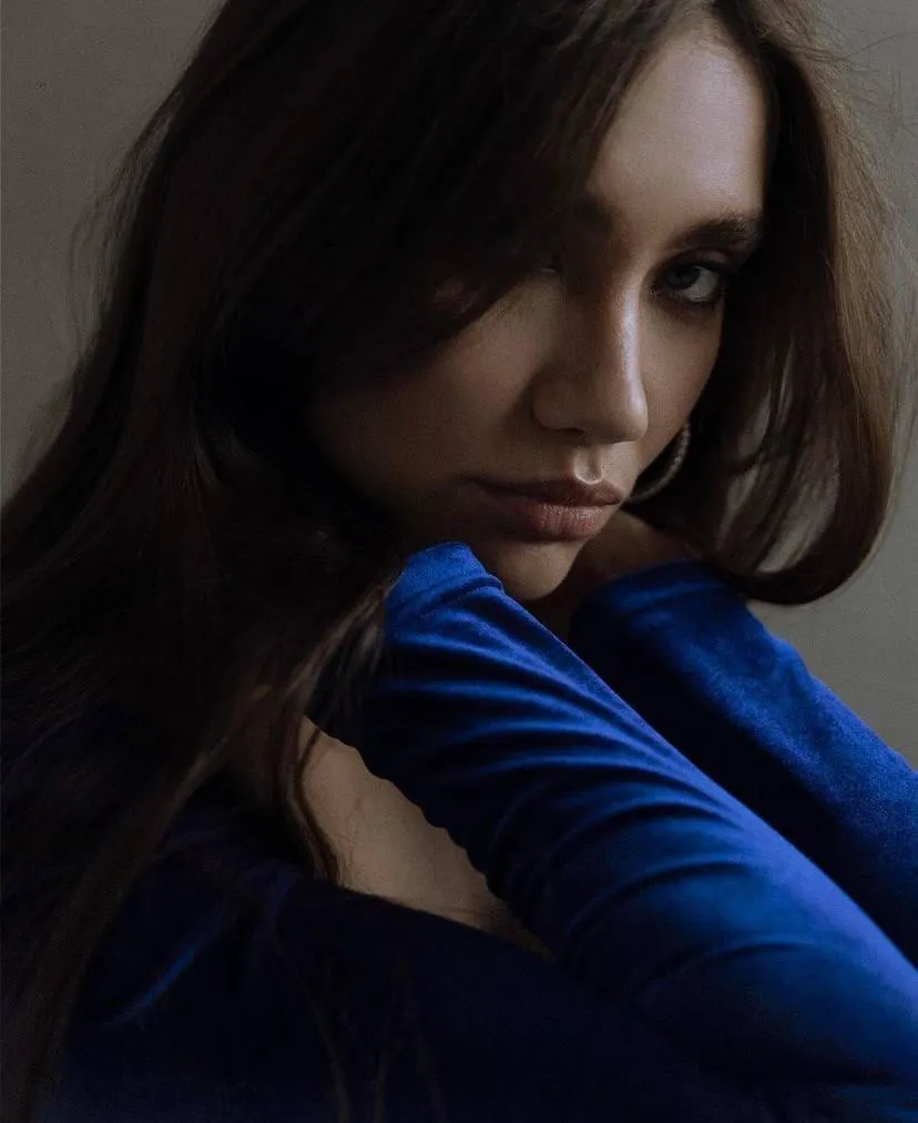 Close up portrait of a woman in a blue long sleeved top