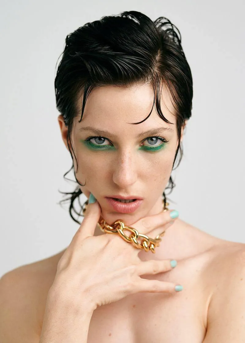 Close up portrait of woman with slicked back hair and makeup