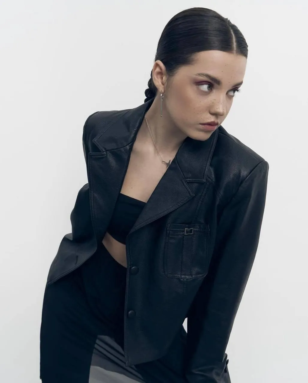 Confident stylish woman in a black jacket posing fiercely