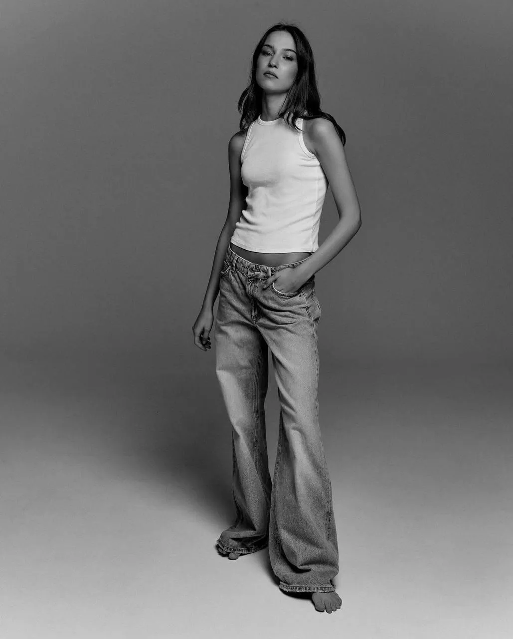 Confident woman in black and white wearing casual jeans