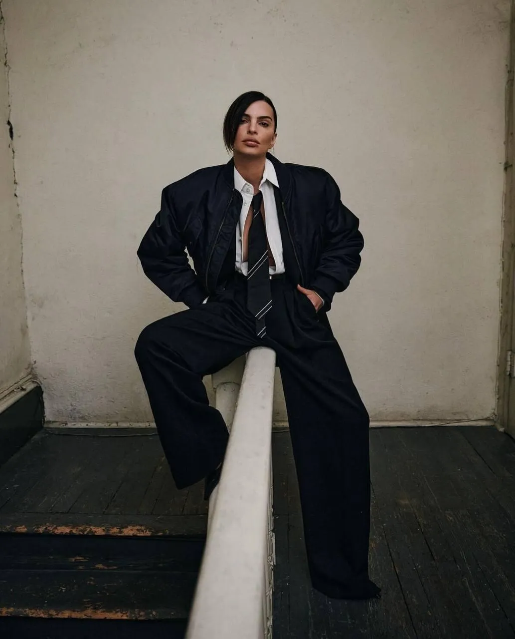 Confident Woman Posing in Dark Oversized Suit in Moody Room