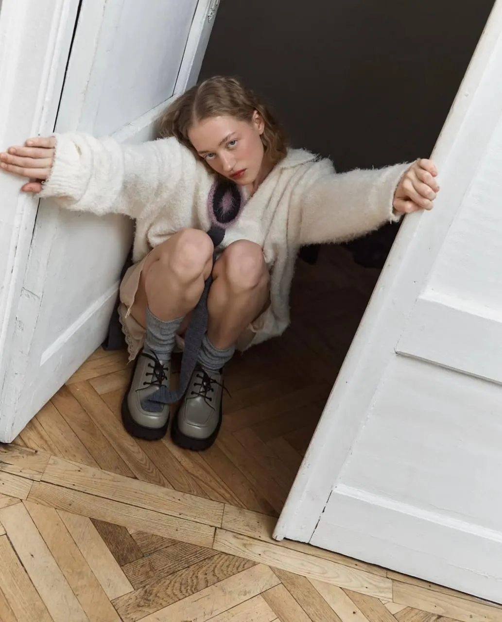 Cozy Fashion Look Sitting by the White Door in Natural Light