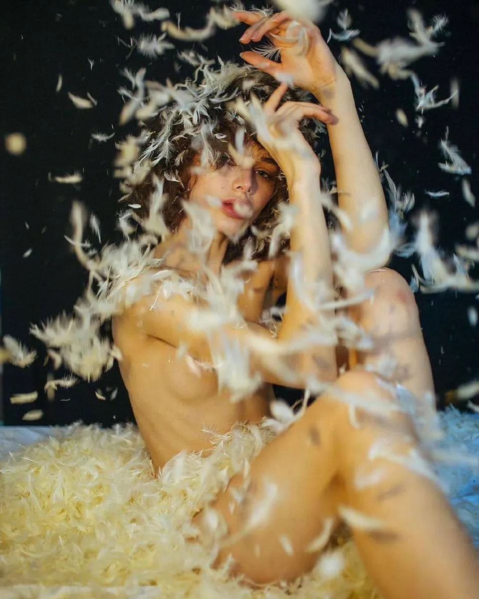 Creative Photo of a Woman Surrounded by Flying Feathers