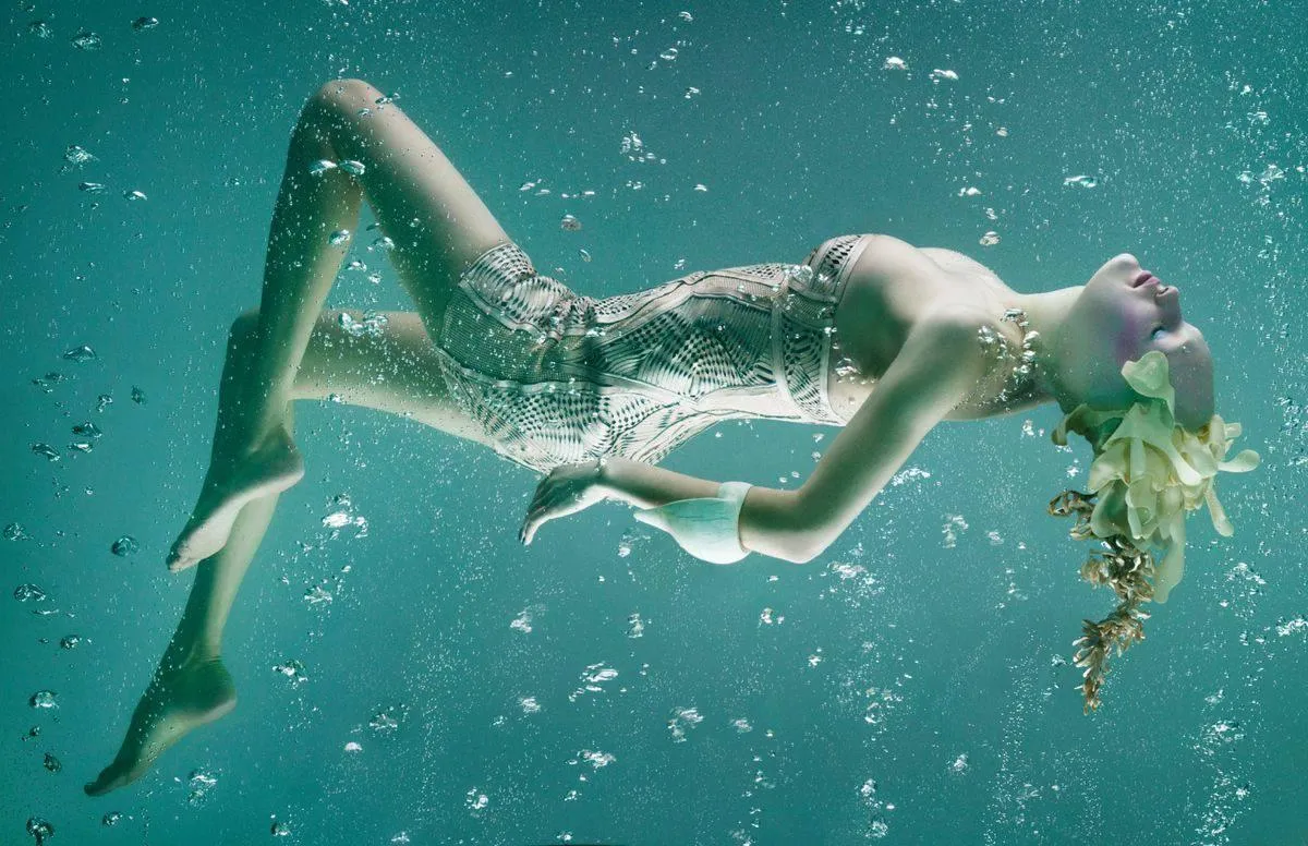 Dreamy Underwater Model Floating in Teal Glowing Water Image