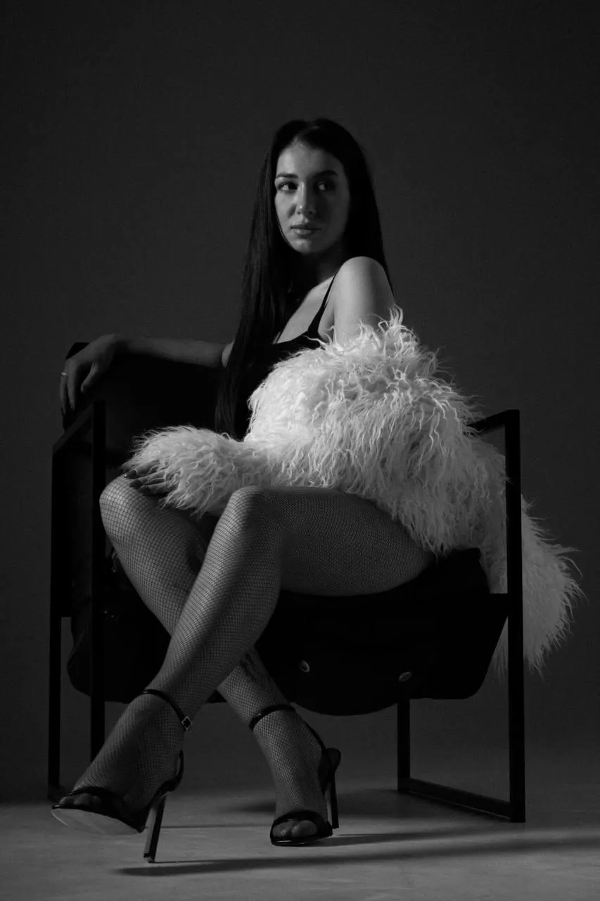 Elegant black and white fashion pose with fur and heels