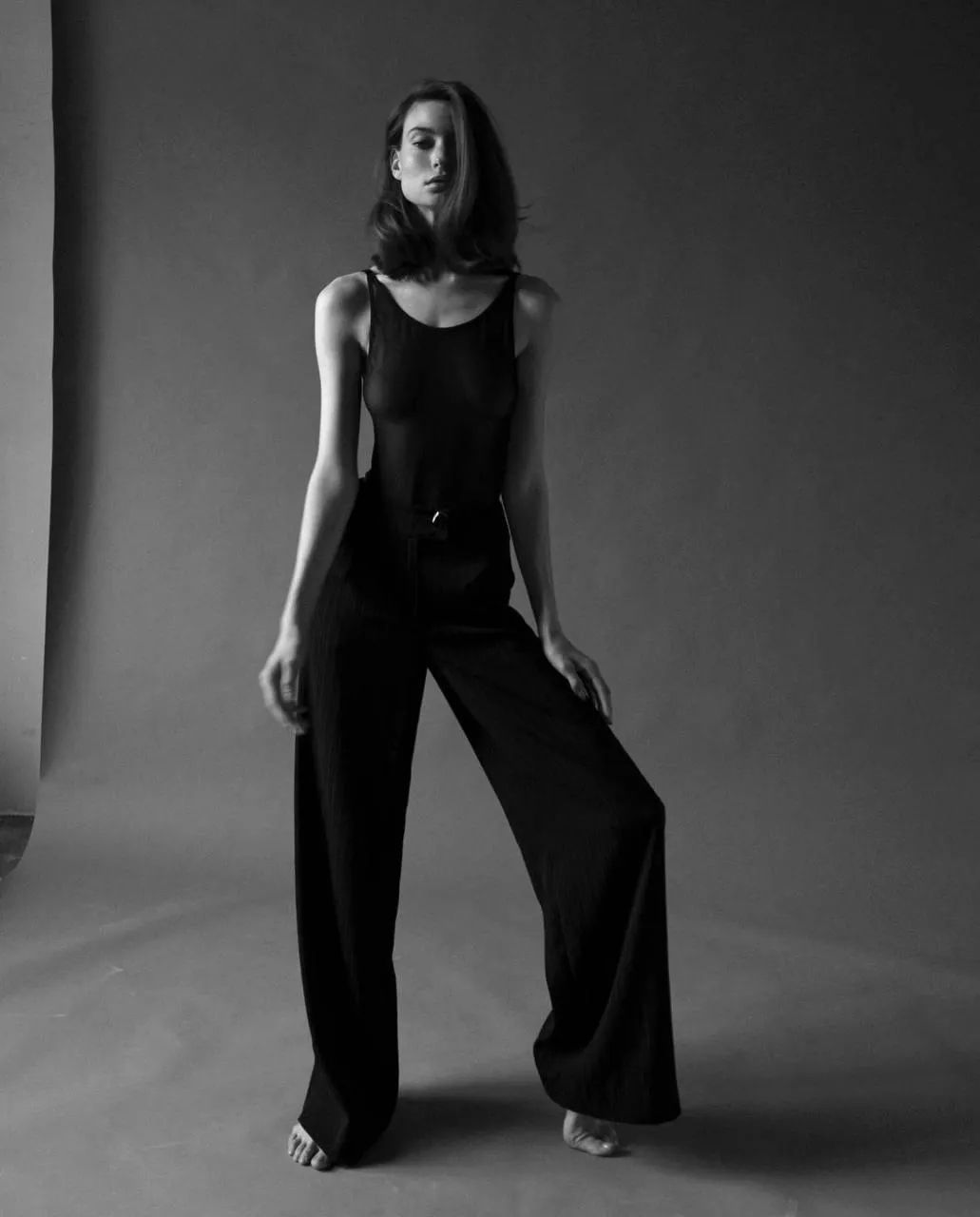 Elegant model in a black jumpsuit posing dark room setting