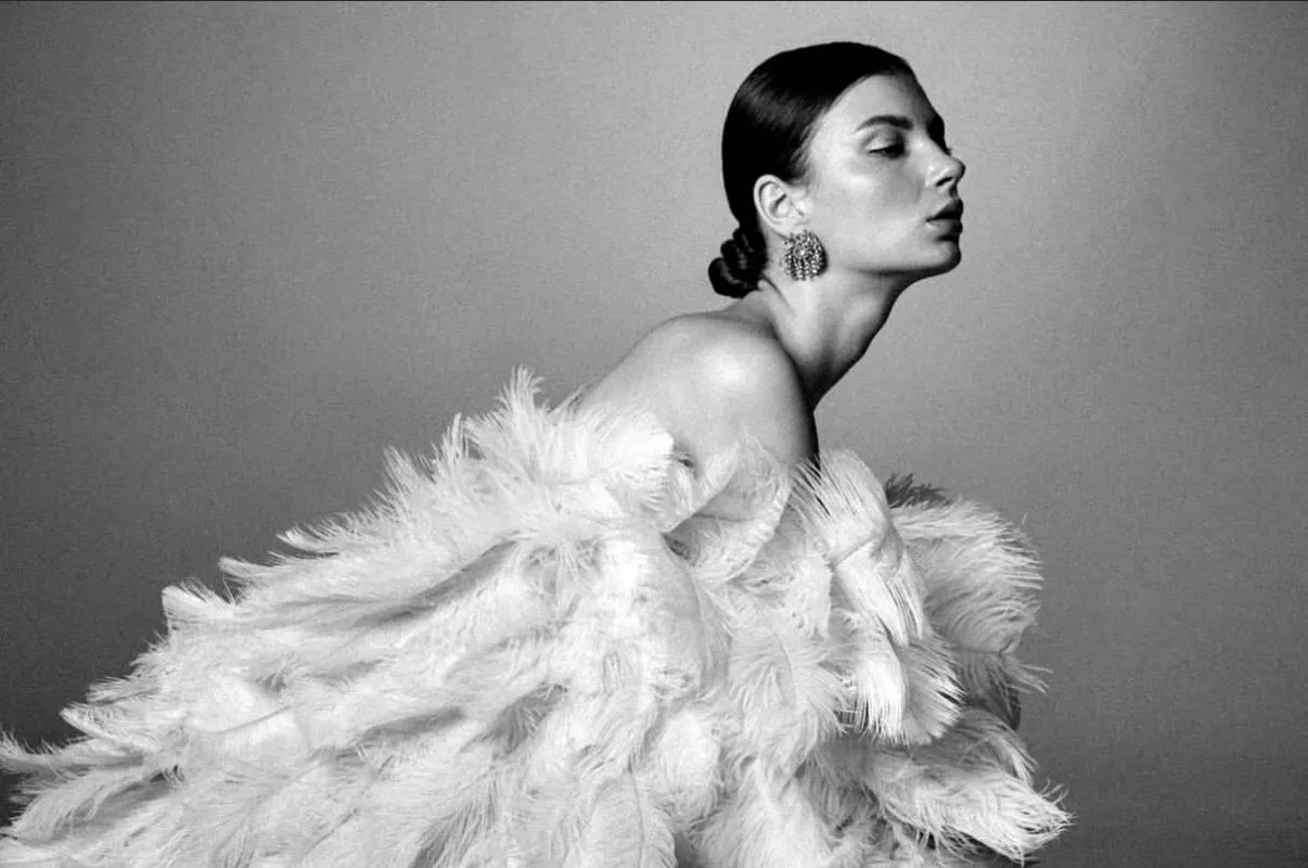 Elegant Model in a Feathered Dress Posing in Black And White