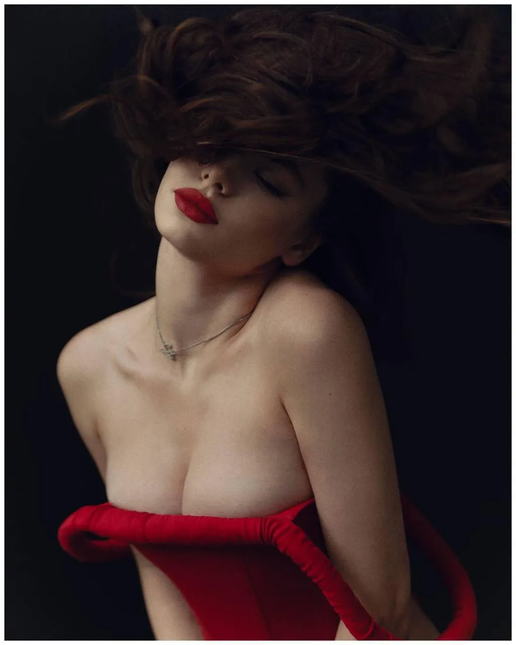 Elegant woman in a red dress with the wind blowing her hair