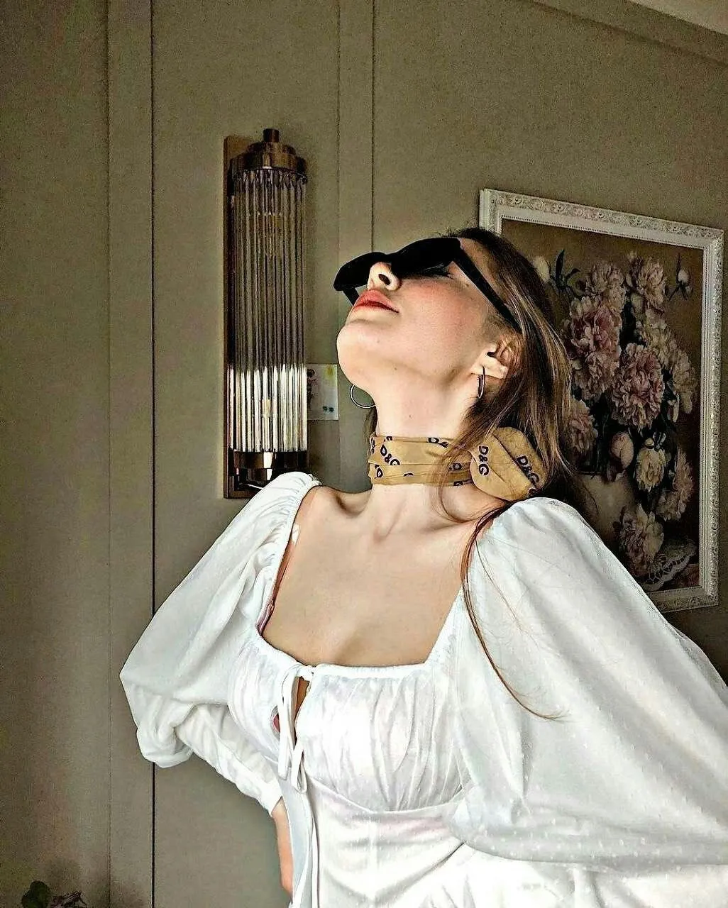 Elegant Woman in a White Dress Tilts Head Toward Sunlight