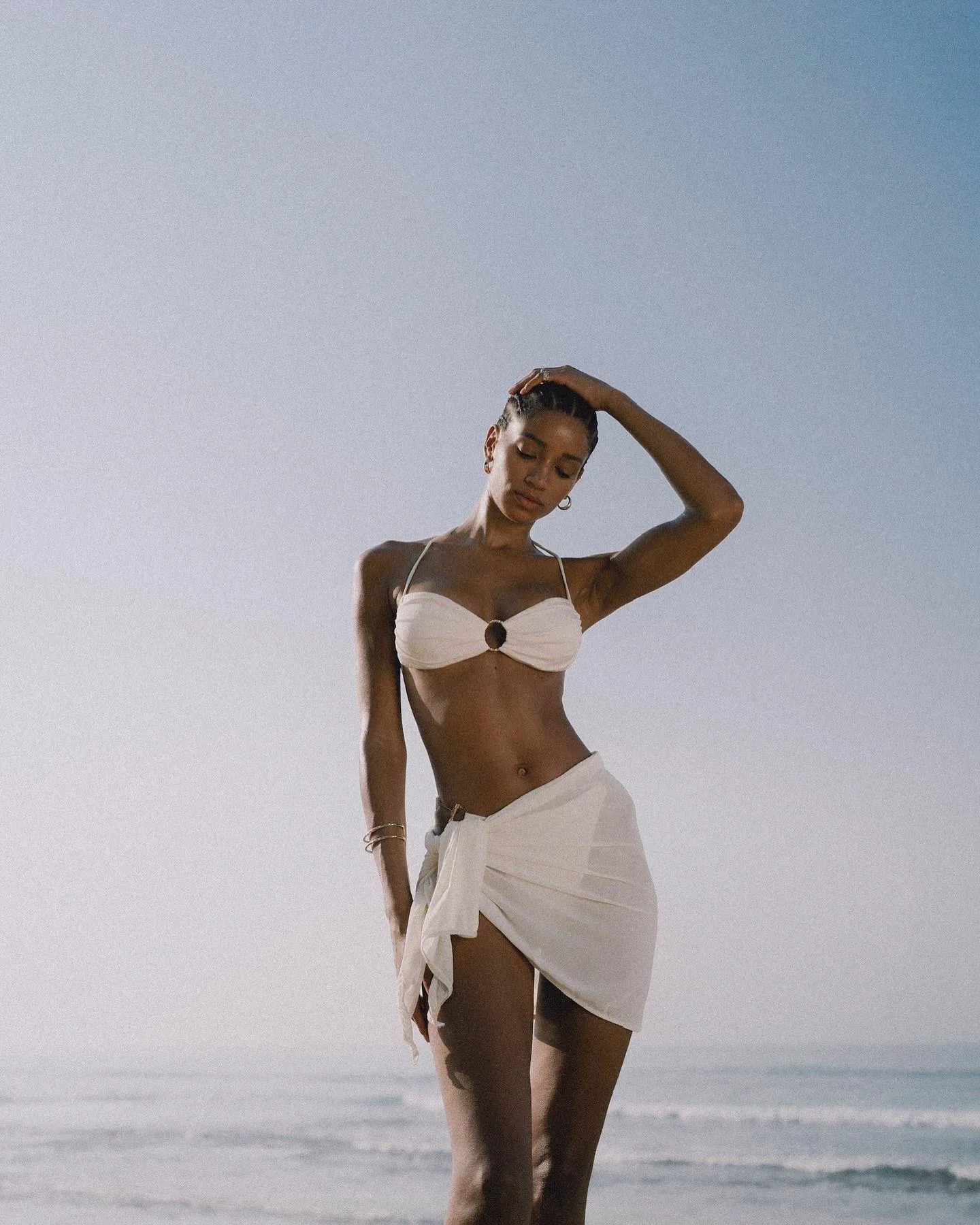 Elegant Woman in a White Skirt Posing by the Ocean Shore