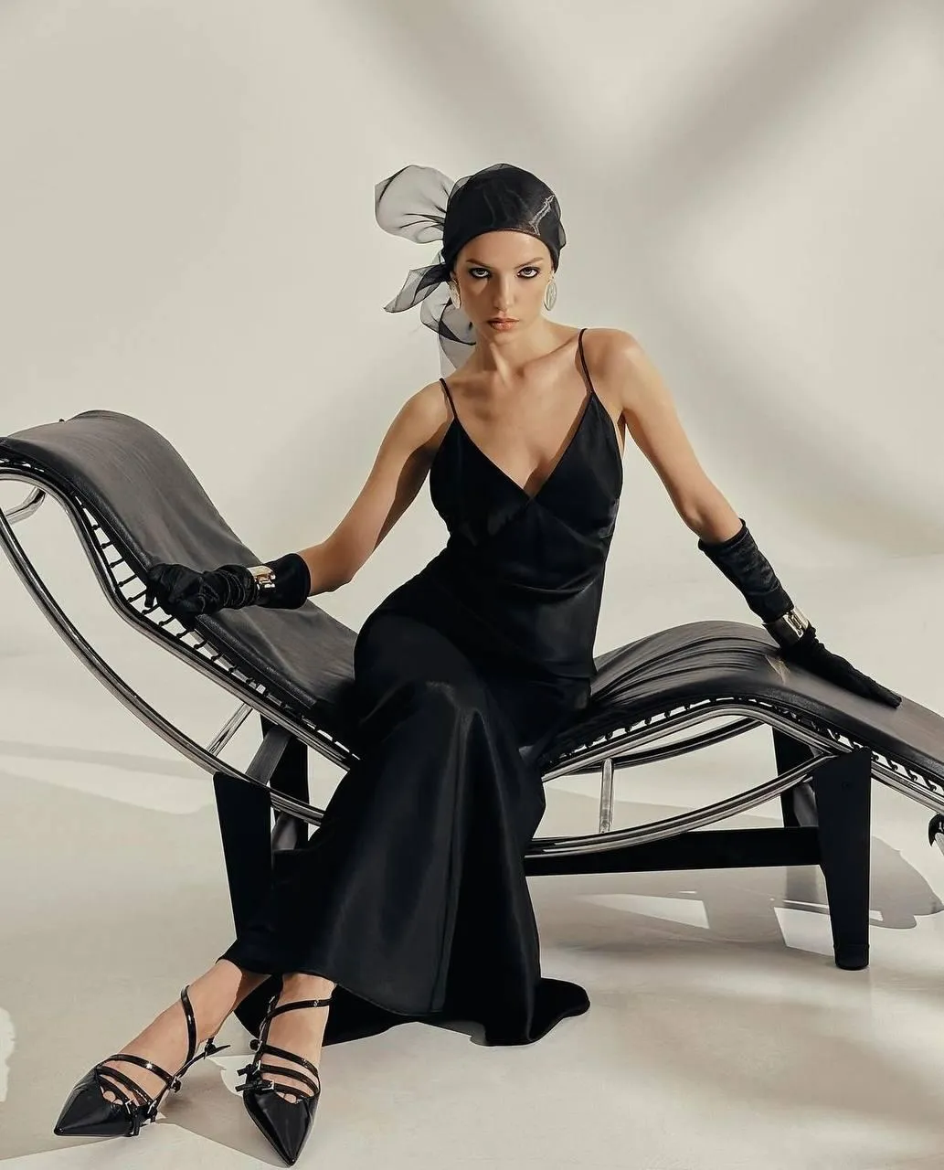 Elegant Woman in Long Black Gown Seated in a Designer Chair