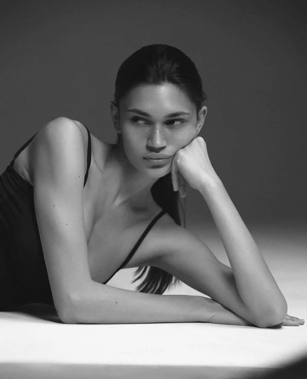 Elegant woman resting chin on her hand in a thoughtful pose