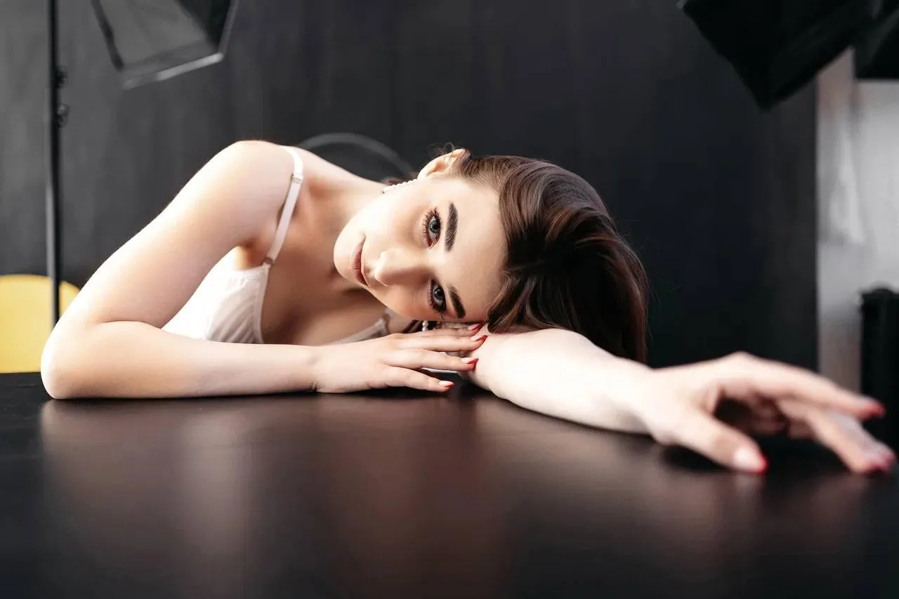 Elegant woman resting her head on folded arms indoors photo