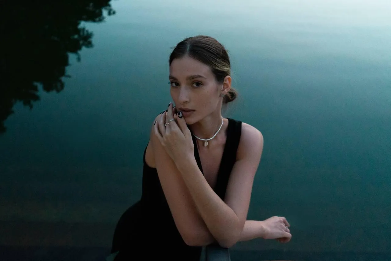 Elegant woman sitting by the lake in a calm serene moment
