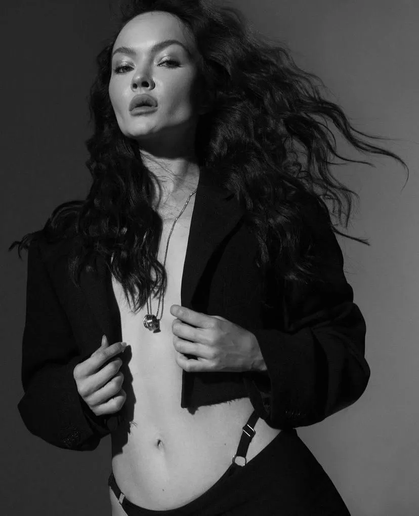 Fashion model in a black jacket posing with wavy hair photo