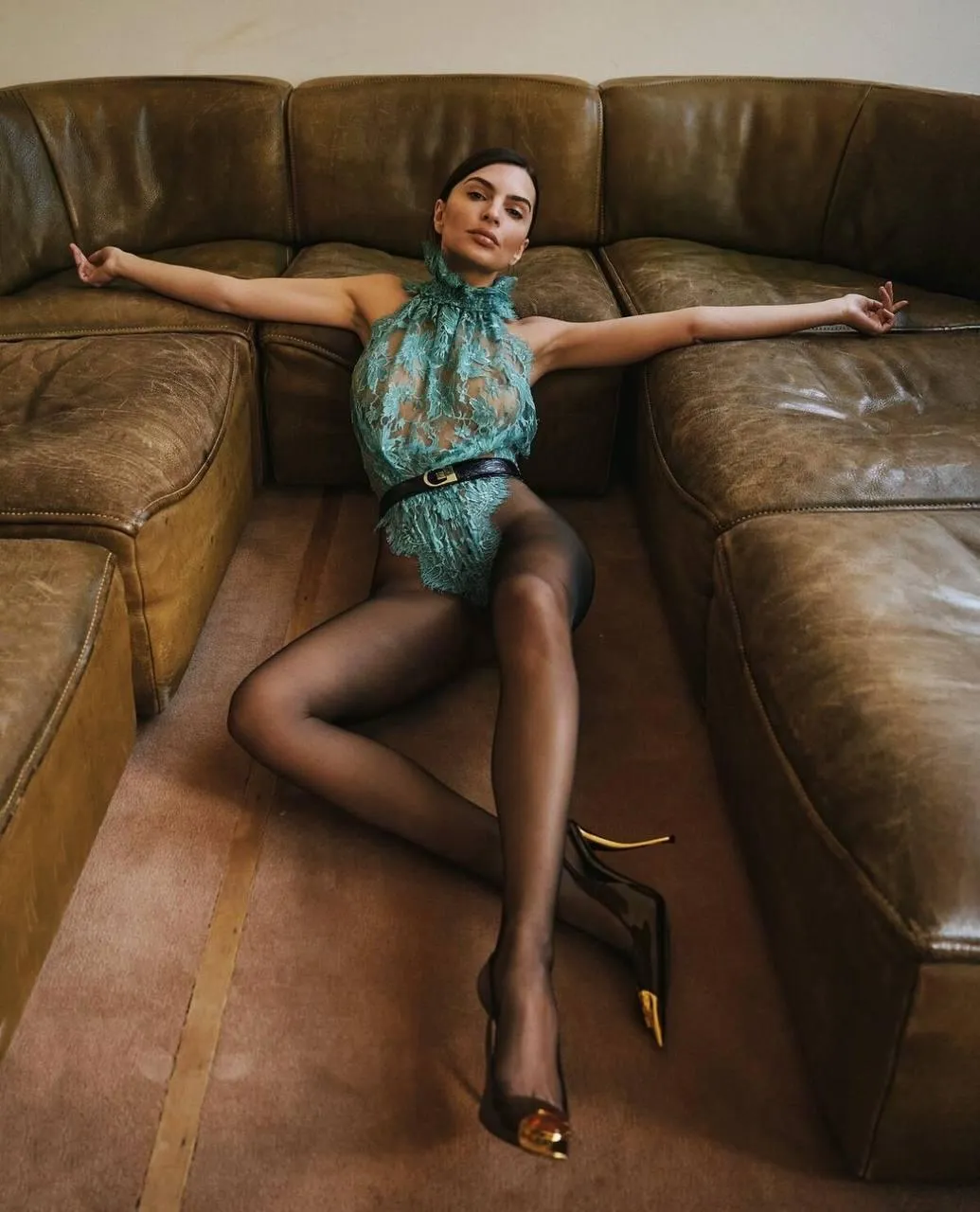Fashion Model Posing on a Leather Couch with Style Wallpaper