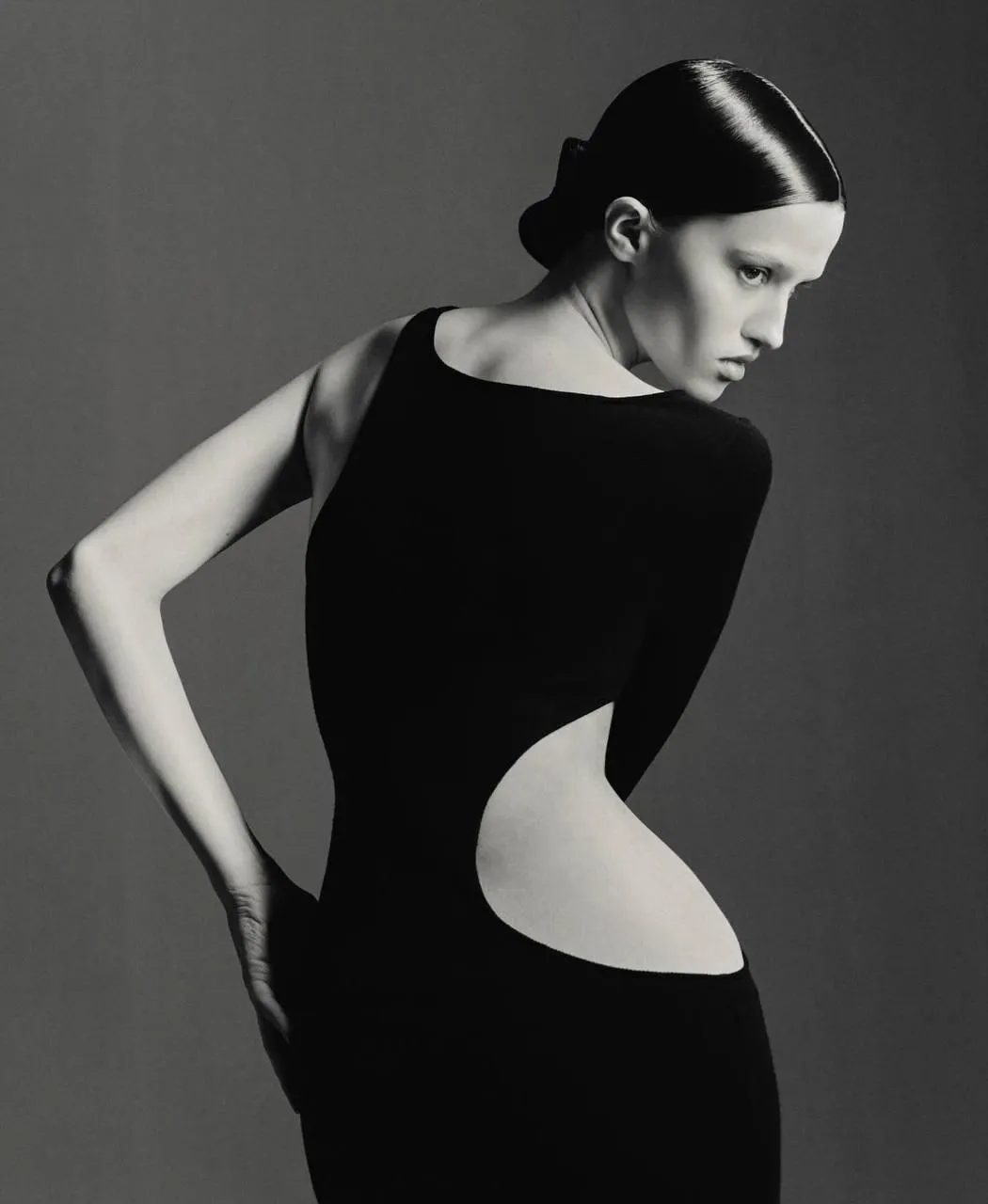 Fashion woman in a cutout black dress posing with grace