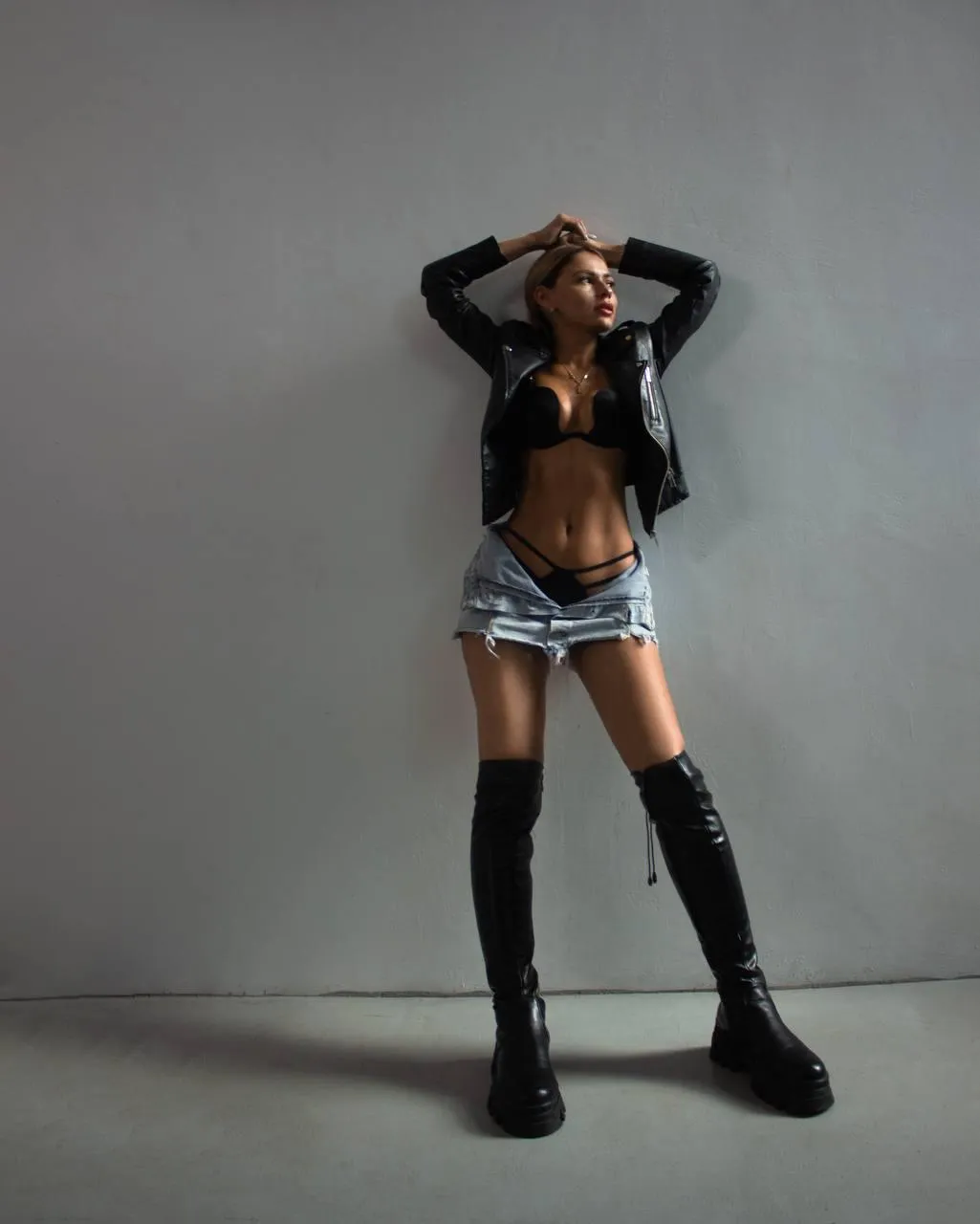 Fashion woman in a skirt and boots striking a bold pose