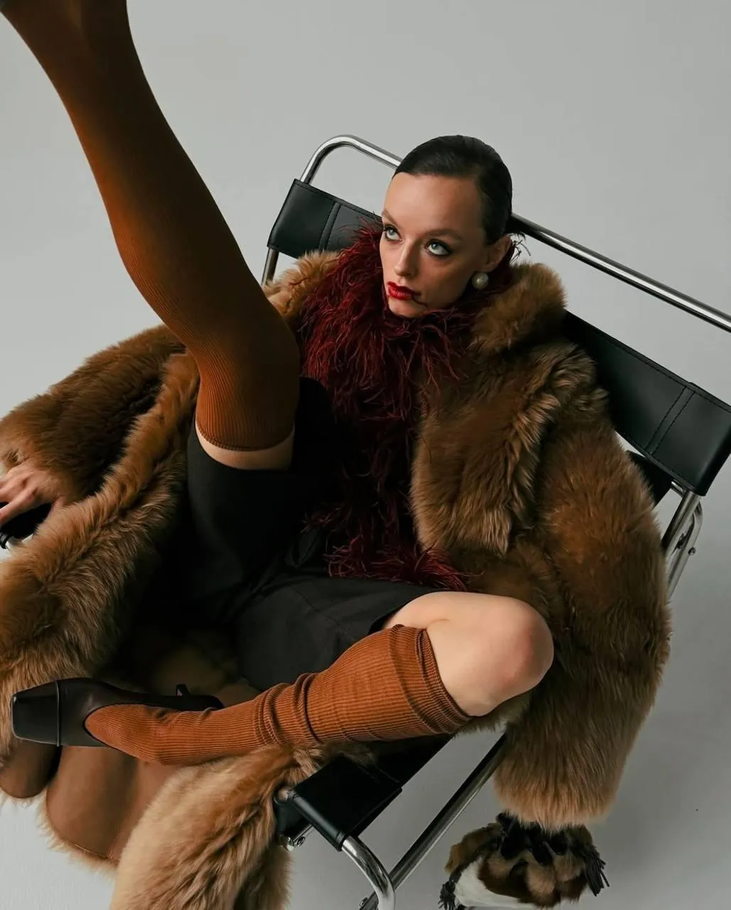 Fashionable Man in a Fur Coat Lounging with a Bold Attitude