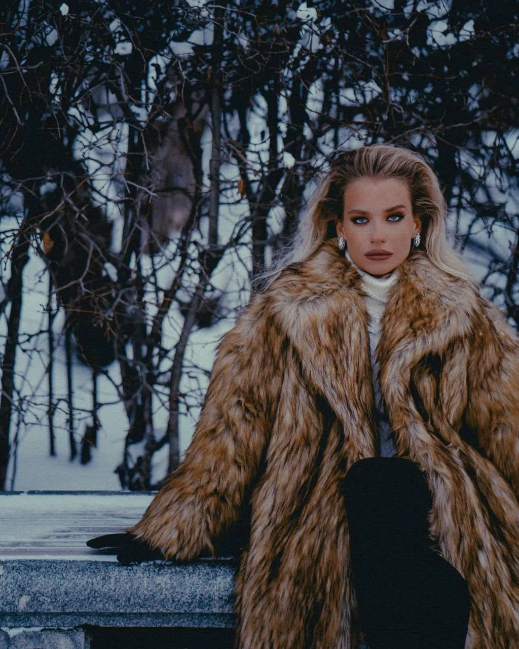 Fashionable Woman in a Fur Coat Posing in a Winter Setting