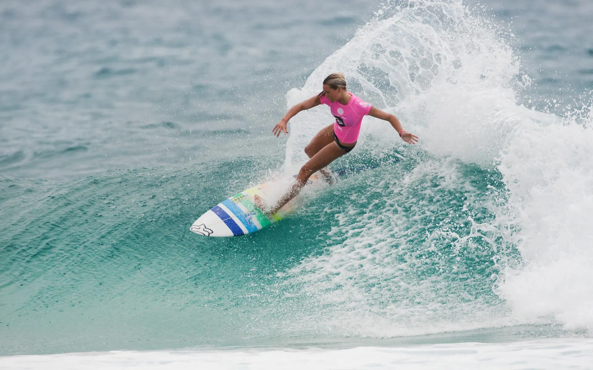 Female Surfer Carving Through a Wave on a Clear Sunny Day