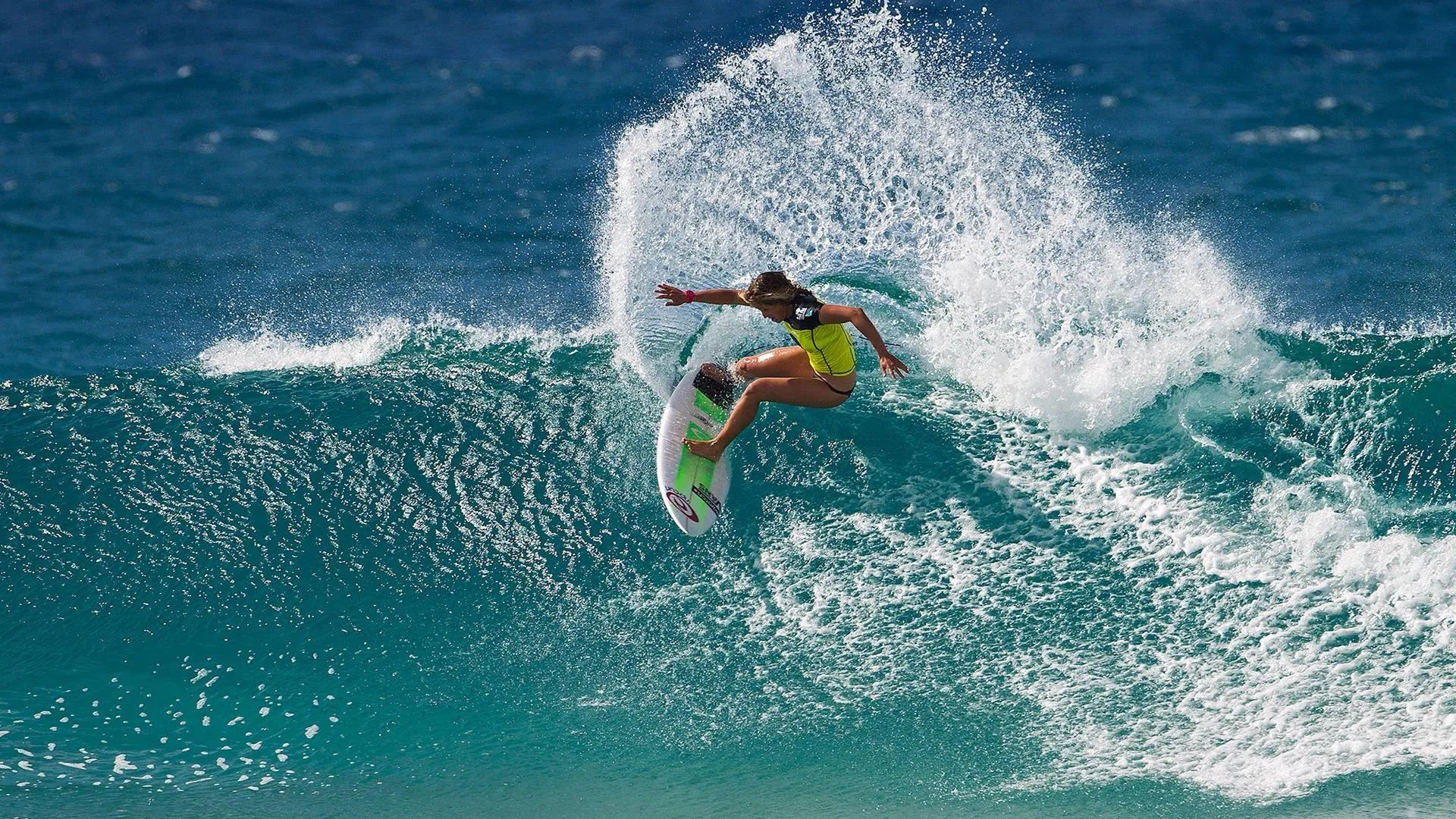 Female Surfer Riding a Fast Wave with Perfect Balance Image
