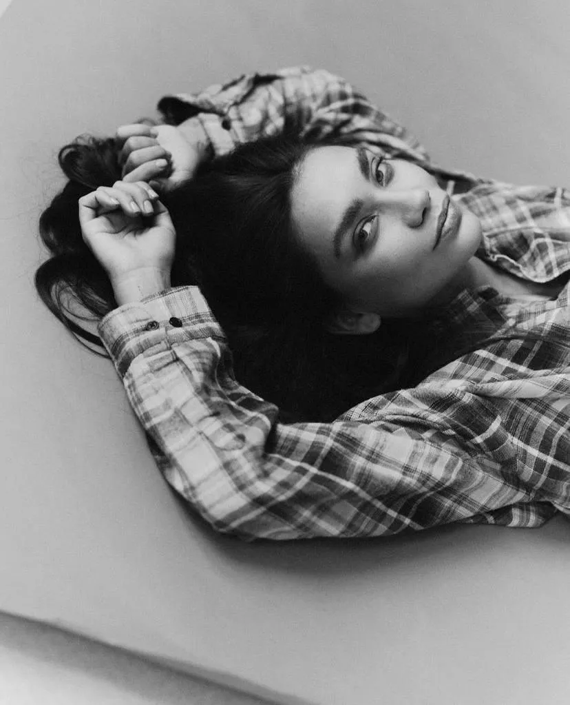 Girl in a checkered shirt lying sideways on her hands image
