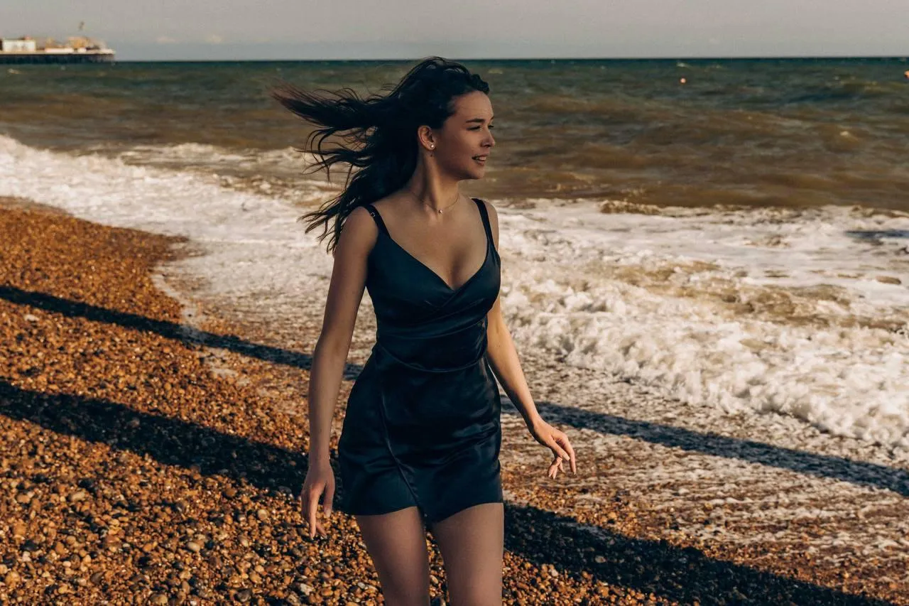 Girl Walking on Rocky Beach in Dark Casual Summer Wear Image