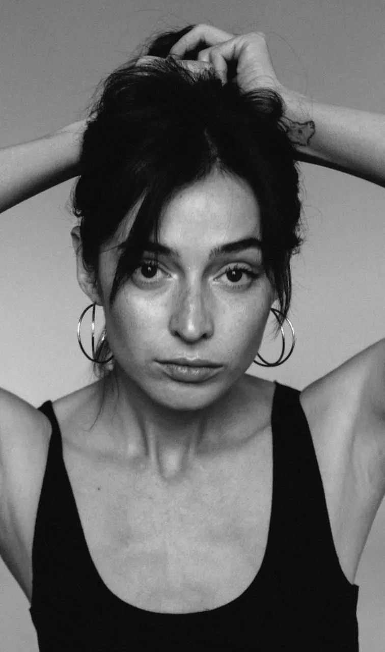 Intense black and white close up of a woman with hand raised