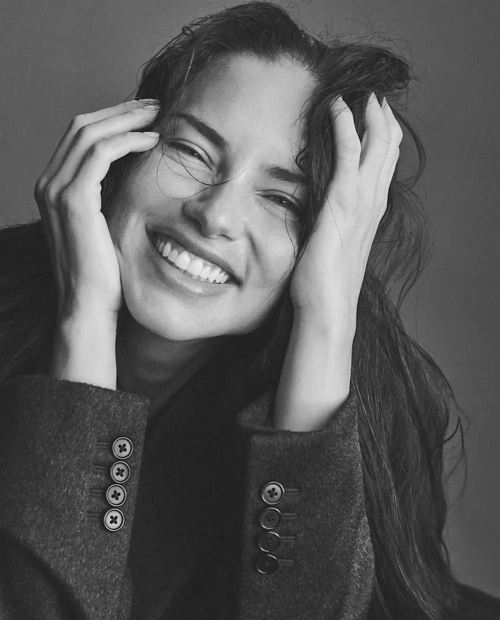 Laughing Woman in a Blazer with Her Hands Touching Her Face