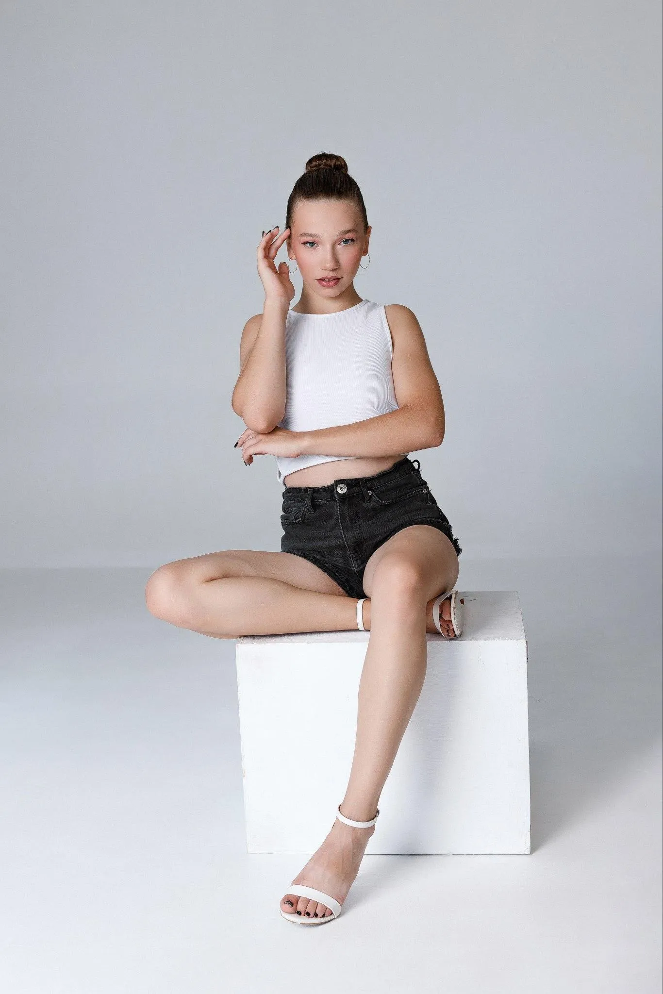 Minimalist Fashion Shoot of a Woman Sitting on a White Cube