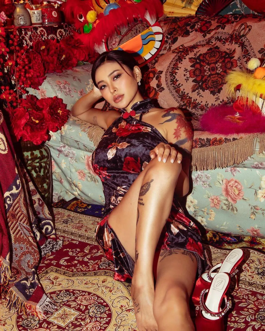 Model Lying on a Vibrant Patterned Rug with Red Flowers