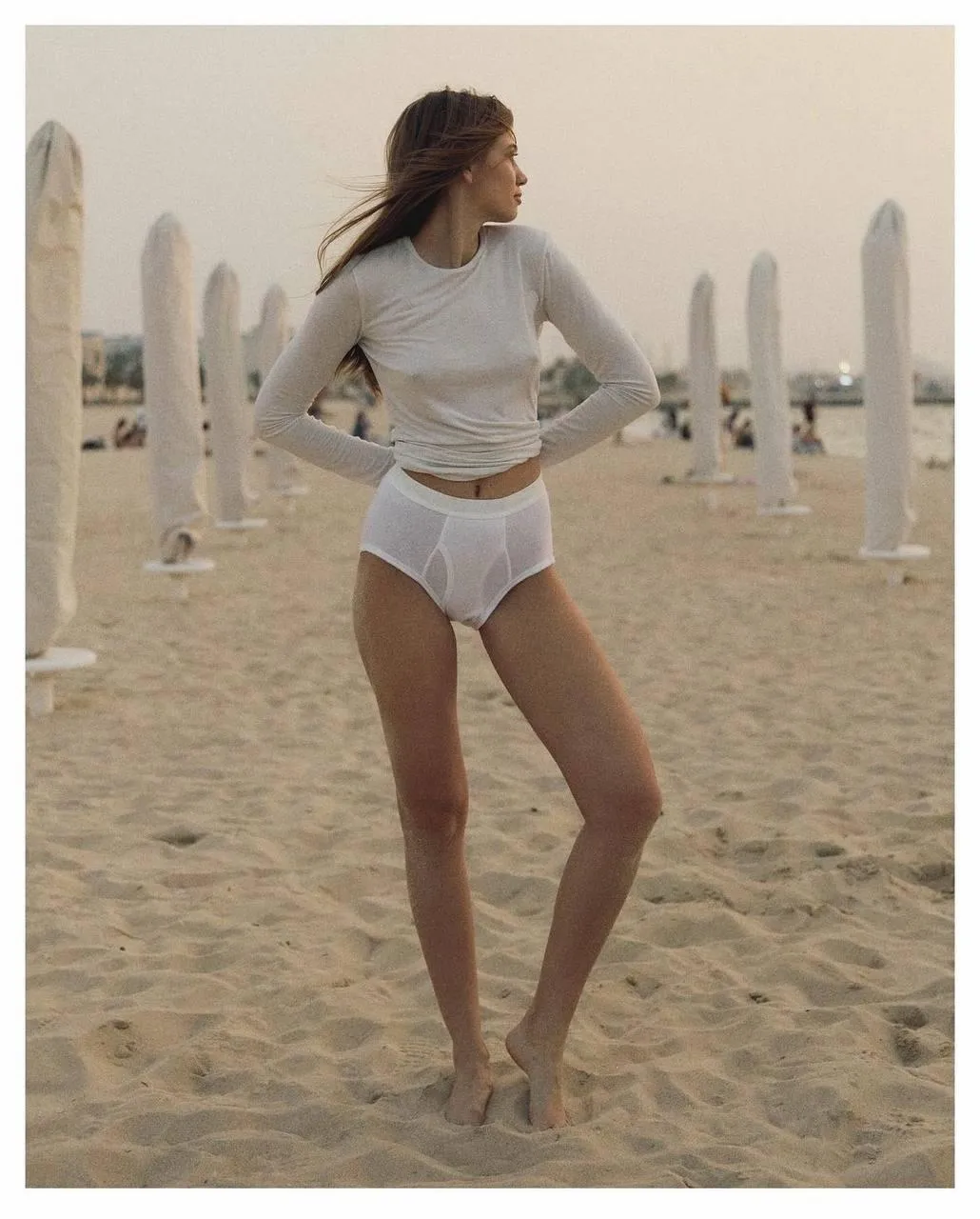 Model Posing in a White Outfit on a Desert Like Sandy Scene
