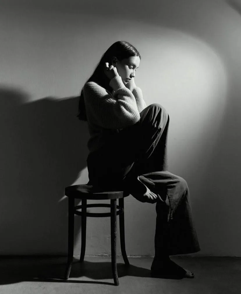 Monochrome of a woman sitting on the chair with one leg up