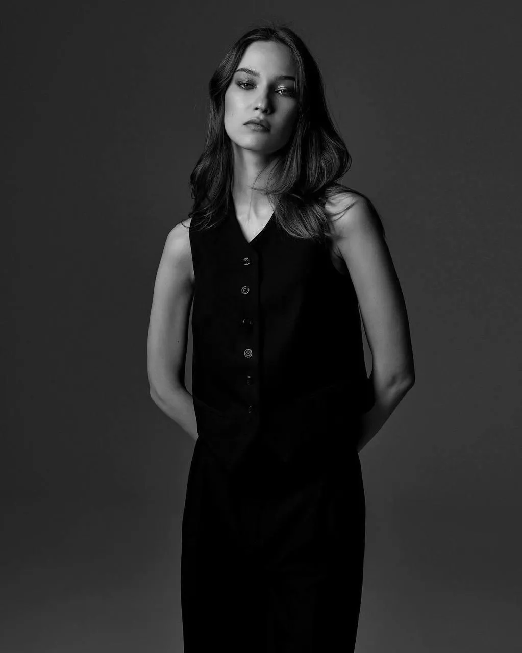 Monochrome of a woman standing calmly against gray backdrop