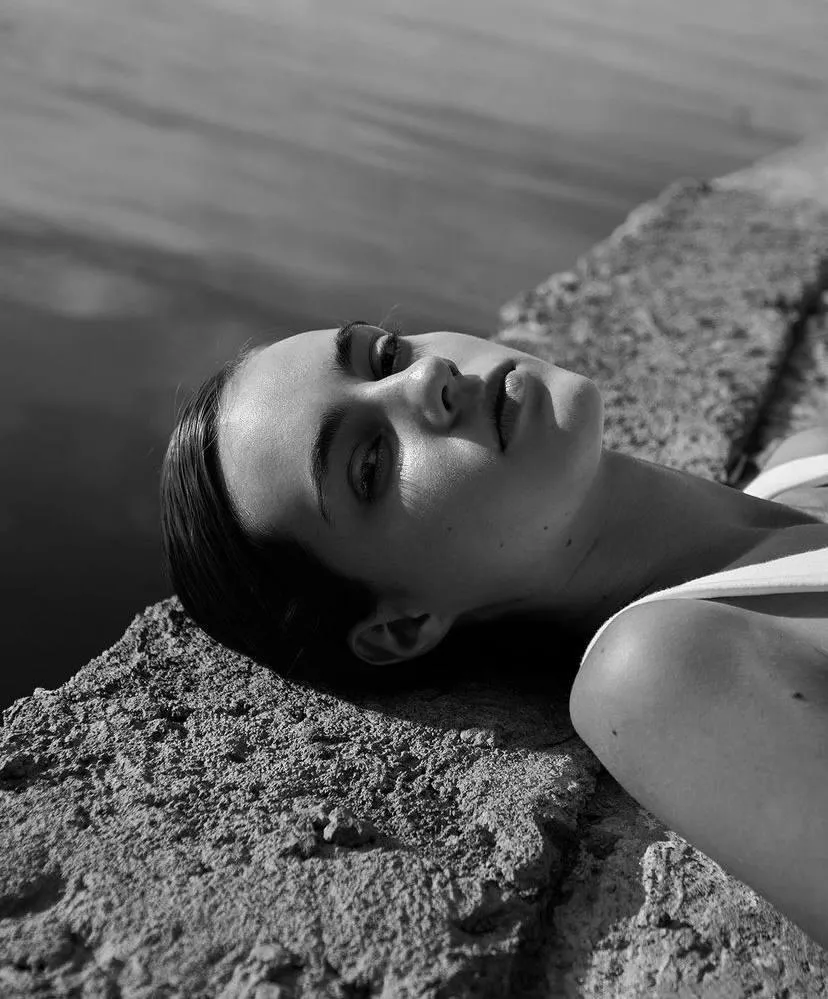 Monochrome Portrait of a Woman Lying Beside a Calm River